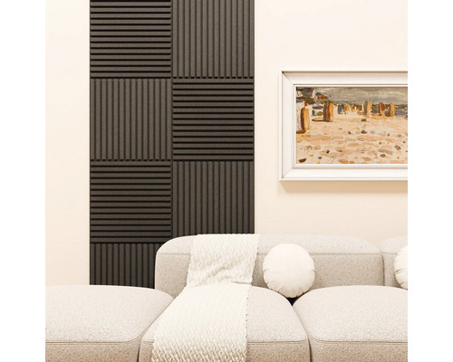 Akustikpaneele mit Lamellenstruktur im Schachbrettmuster an der Wand hinter einem Sofa in einem Wohnzimmer.