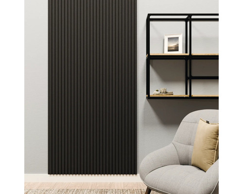 Modernes Wohnzimmer mit einem vertikalen, dunklen Akustikpaneel an der Wand neben einem schwarzen Metallregal und einem grauen Sessel.