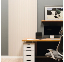 Modernes Büro mit vertikalem Wandpaneel in Lattenoptik, Holzschreibtisch, weißen Schubladen und ergonomischem Stuhl vor einer grauen Wand.
