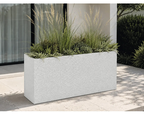 Rechteckiger Pflanzkübel in Granit-Optik auf einer modernen Terrasse, bepflanzt mit Ziergräsern und Pflanzen vor einer Hausfassade.