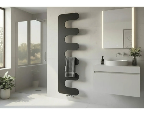 Moderner, wellenförmiger Design-Heizkörper in einem hellen Badezimmer neben einem Waschtisch mit Spiegel und einer Glasdusche.