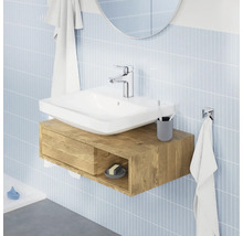 Modernes Badezimmer mit Aufsatzwaschbecken auf einem wandhängenden Waschtischunterschrank in Holzoptik vor einer gefliesten Wand.