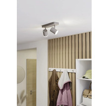 Moderner zweiflammiger Deckenstrahler in einem hellen Flur mit Wandpaneelen aus Holzlamellen und einer Garderobe.
