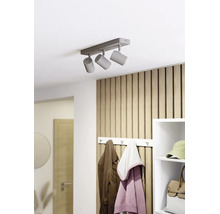 Dreiflammiger Deckenstrahler an einer Decke in einem hellen, organisierten Flur mit Holzpaneelwand, Garderobe und weißem Regal.