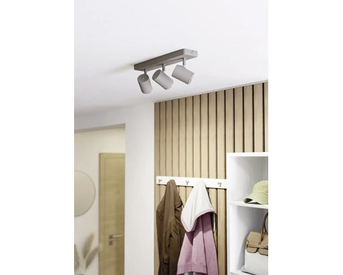 Dreiflammiger Deckenstrahler an einer Decke in einem hellen, organisierten Flur mit Holzpaneelwand, Garderobe und weißem Regal.