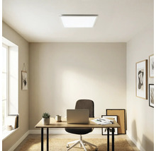 Heller, organisierter Arbeitsraum mit einem quadratischen LED-Panel an der Decke, Holzschreibtisch mit Laptop und Bürostuhl.