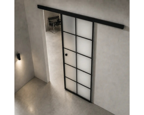 Moderne, helle Raumgestaltung mit einer Schiebetür im Industriedesign aus schwarzem Metall und Milchglas in Gitteroptik auf einem Betonboden.