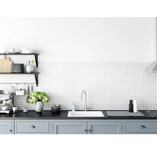 Moderne, helle Küche mit geometrisch gemustertem Fliesenspiegel, weißer Einbauspüle, Armatur aus Chrom und grauen Unterschränken.