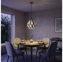 Modernes Esszimmer mit einer geometrischen Pendelleuchte über einem runden Holztisch und vier gepolsterten Stühlen.
