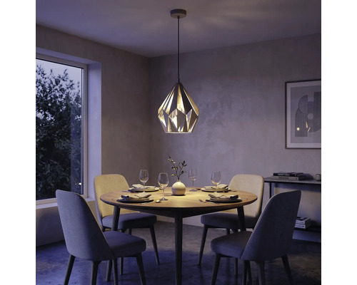 Modernes Esszimmer mit einer geometrischen Pendelleuchte über einem runden Holztisch und vier gepolsterten Stühlen.