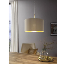 Moderne Pendelleuchte mit beigem Textilschirm und goldener Innenseite über einem Esstisch aus Holz in einem hellen Raum.