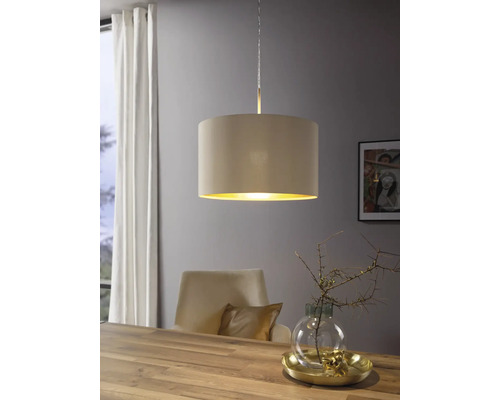 Moderne Pendelleuchte mit beigem Textilschirm und goldener Innenseite über einem Esstisch aus Holz in einem hellen Raum.