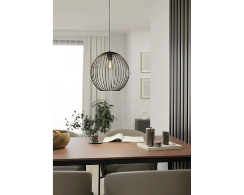 Moderne Pendelleuchte aus schwarzem Drahtgeflecht über einem Esstisch aus Holz in einem hellen, minimalistischen Esszimmer.