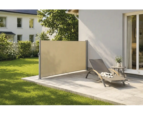 Moderne Seitenmarkise aus Stoff als Sicht- und Windschutz auf einer Steinterrasse mit Sonnenliege und angrenzender Rasenfläche.