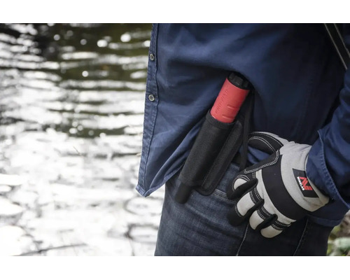 Minelab Pro-Find Pinpointer-Metalldetektor in einem Holster am Gürtel einer Person mit Arbeitshandschuh im Freien an einem Gewässer.