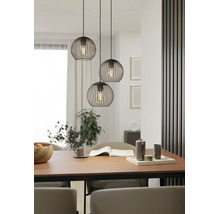 Dreiflammige Pendelleuchte mit schwarzen Drahtschirmen in Kugelform über einem Esstisch aus Holz in einem modern gestalteten Esszimmer.