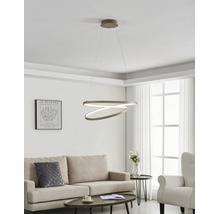 Moderne Wohnzimmereinrichtung mit einer ringförmigen LED-Pendelleuchte über einem beigen Sofa und einem dunklen Couchtisch.