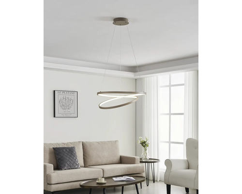 Moderne Wohnzimmereinrichtung mit einer ringförmigen LED-Pendelleuchte über einem beigen Sofa und einem dunklen Couchtisch.
