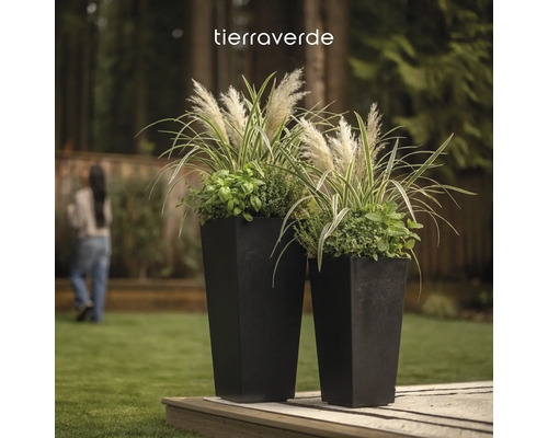 Zwei hohe quadratische Pflanzgefäße mit Gräsern und Kräutern auf einem Holzdeck im Garten. Tierraverde Logo.