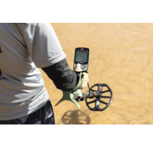 Person verwendet einen Minelab X-TERRA PRO Metalldetektor auf sandigem Untergrund.