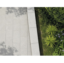 Terrassenplatten und Mauersteine aus Granit im Außenbereich mit Bepflanzung.