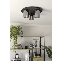 Moderne Deckenleuchte mit Metallsockel und Glasschirmen in einem hellen Raum mit dekorativem Regal und Zimmerpflanzen.