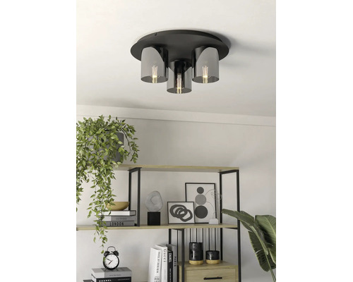 Moderne Deckenleuchte mit Metallsockel und Glasschirmen in einem hellen Raum mit dekorativem Regal und Zimmerpflanzen.