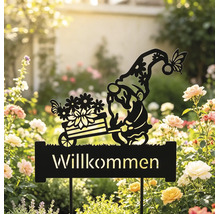 Gartenstecker aus schwarzem Metall mit einer Zwergen-Silhouette, der einen Blumenwagen über einem Willkommen-Schild schiebt, in einem Rosenbeet.