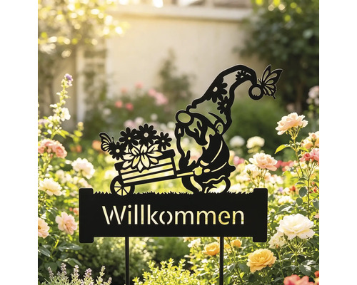 Gartenstecker aus schwarzem Metall mit einer Zwergen-Silhouette, der einen Blumenwagen über einem Willkommen-Schild schiebt, in einem Rosenbeet.