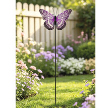 Gartenstecker mit einem lila und weiß gemusterten Schmetterling, platziert in einem hellen Garten mit Blumen und einem Holzzaun.