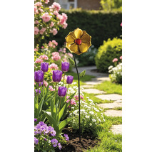 Gartenstecker aus Metall in Blumenform mit goldfarbener Blüte, rotem Zentrum und grünen Blättern in einem Blumenbeet mit Tulpen und Gänseblümchen.