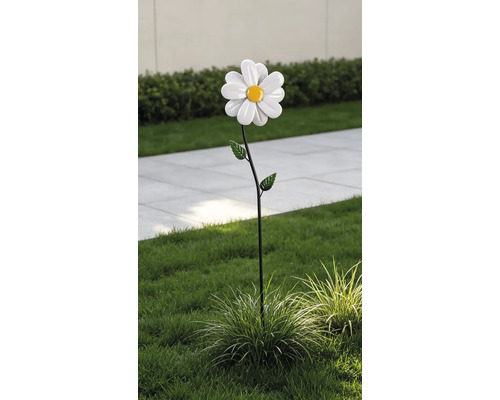 Gartenstecker aus Metall in Form einer Margerite mit weißen Blütenblättern und gelber Mitte, im Rasen einer Gartenanlage platziert.