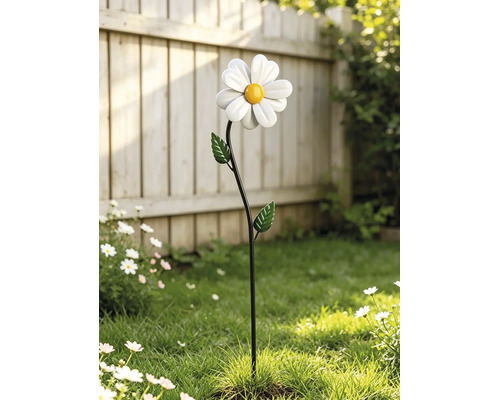Gartenstecker in Form einer weißen Margerite mit gelber Mitte und grünen Blättern in einem Garten.
