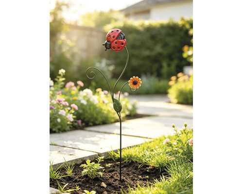 Gartenstecker aus Metall mit Marienkäfer, kleiner Blüte und Blatt in einem Blumenbeet.