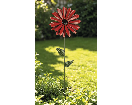 Gartenstecker aus Metall in Form einer Blume mit zwei Blättern am Stiel, platziert in einem Gartenbeet.