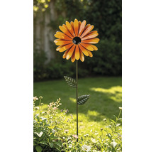 Gartenstecker aus Metall in Form einer orangefarbenen Blume mit schwarzer Mitte und grünem Stiel mit Blättern in einem Garten.