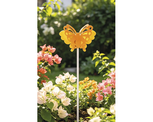 Dekorativer Gartenstecker mit Schmetterlingsmotiv in einem hellen blühenden Gartenbeet.