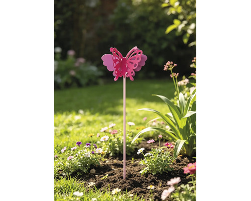 Beetstecker mit Schmetterlingsmotiv in einem Gartenbeet zwischen Blumen.