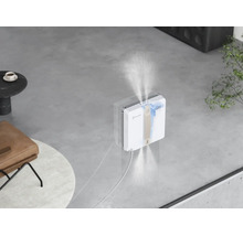 Ein automatischer Fensterputzroboter von Ecovacs, der Wasser auf die Glasfläche sprüht, um diese effizient zu reinigen.