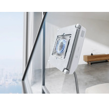 Ein automatischer Fensterputzroboter reinigt eine große Fensterscheibe in einem modernen Wohnzimmer.