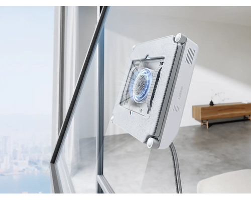 Ein automatischer Fensterputzroboter reinigt eine große Fensterscheibe in einem modernen Wohnzimmer.