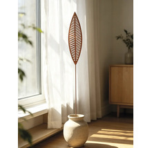 Gartenstecker aus Metall in Blattform mit Aussparungen und Rost-Optik, stehend in einer Steinvase vor einem hellen Fenster mit Vorhängen.