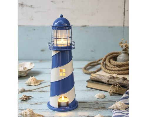 Maritime Leuchtturm-Laterne aus Metall mit blau-weißen Streifen, dekoriert in einer hellen Szene mit Muscheln, Seil und Treibholz auf Holzoberfläche.