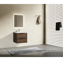 Moderner Badezimmerschrank in Holzoptik mit weißem Waschbecken, Armatur und beleuchtetem Wandspiegel in einem hellen, strukturierten Badezimmer.