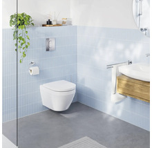 Modernes Badezimmer mit wandhängendem Tiefspül-WC, hellblauen Wandfliesen, grauem Boden und Waschbecken mit Holzunterschrank.