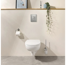 Wand-WC mit geschlossenem Deckel, Betätigungsplatte, Toilettenpapierhalter und WC-Bürste in modernem Badezimmer.