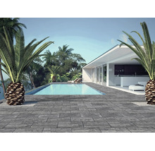 Moderne Terrasse mit Bodenplatten in Steinoptik, einem Swimmingpool und einem weißen Haus umgeben von Palmen.