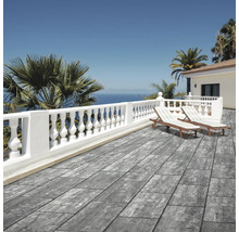 Moderne Terrasse mit grauen Terrassenplatten in Steinoptik, weißer Balustrade, Sonnenliegen und Meerblick in hellem mediterranem Ambiente.