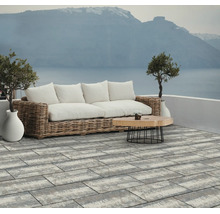 Großformatige grau-weiße Terrassenplatten in Rechteckform auf einer modernen Terrasse mit Loungemöbeln und Meerblick.