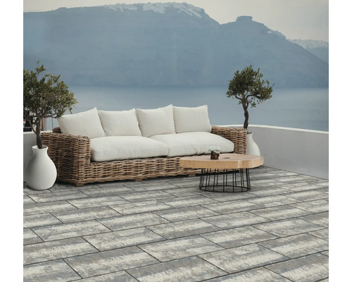 Großformatige grau-weiße Terrassenplatten in Rechteckform auf einer modernen Terrasse mit Loungemöbeln und Meerblick.